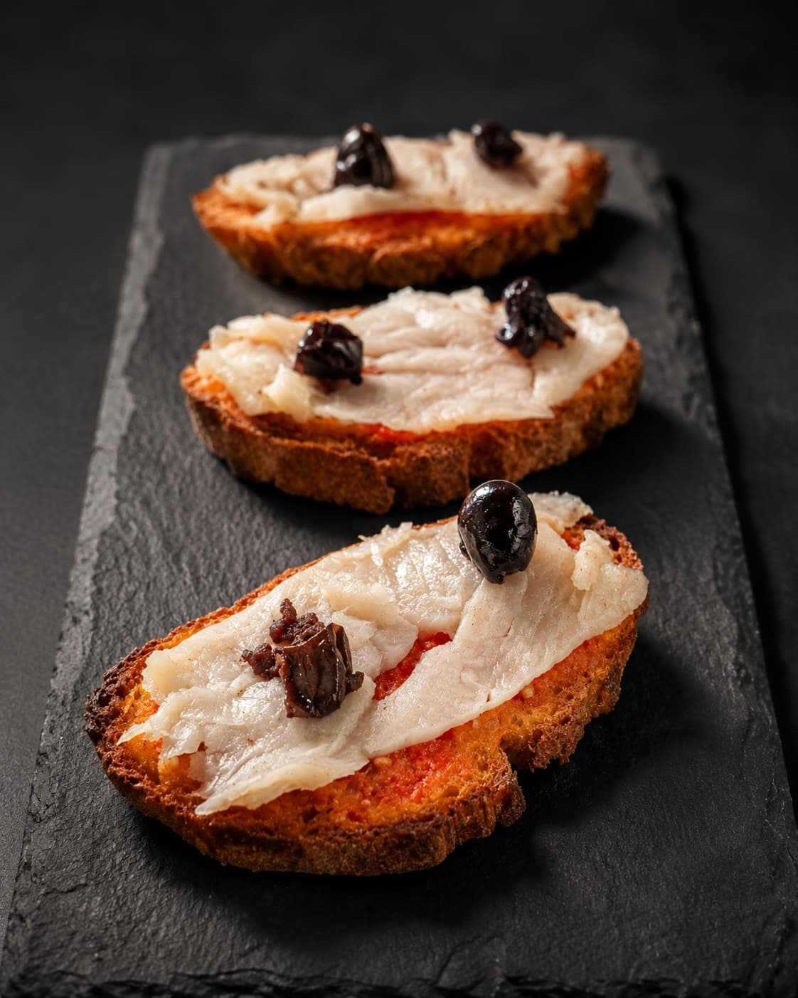 Carpaccio de bacalao con pulpa de tomate y aceituna negra
